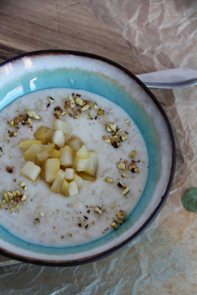 Creamy winter oatmeal with almond butter and banana in a warm bowl